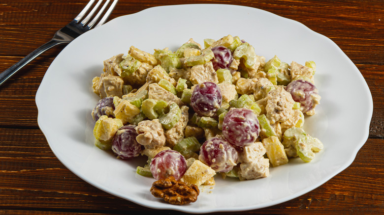 Chicken salad with grapes, celery, and walnuts on white plate