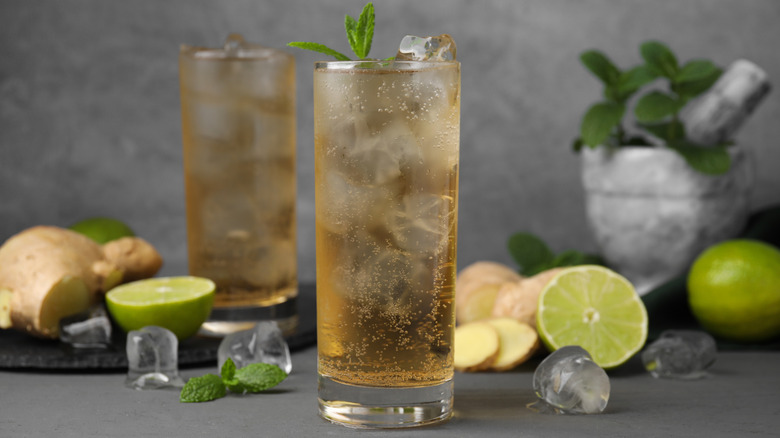 Glasses of iced ginger ale by ginger and limes